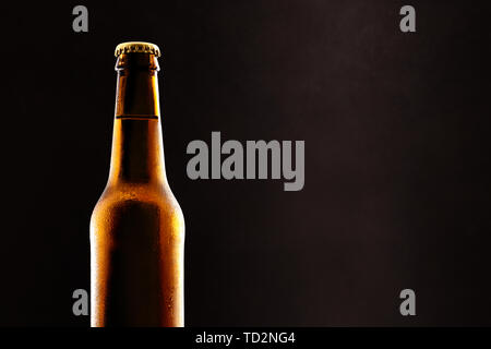 Beer bottle filled and closed close up and black background. Horizontal composition. Front view. Stock Photo