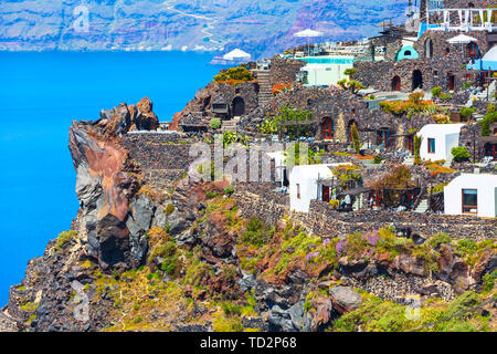 Santorini, Greece white houses architecture with caldera blue sea view and flowers blossom in famous island Stock Photo