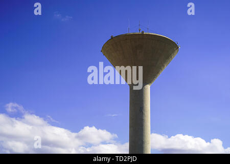 Concrete water tower on blue sky background Stock Photo