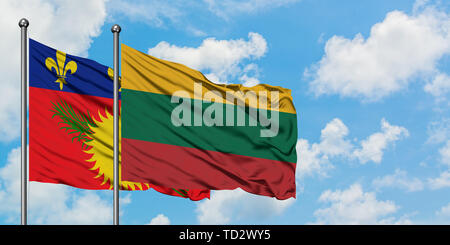 Guadeloupe and Lithuania flag waving in the wind against white cloudy blue sky together. Diplomacy concept, international relations. Stock Photo