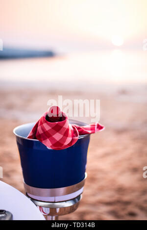 Bottle of wine chilled on a beach for a romantic dinner Stock Photo