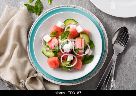 Watermelon salad with feta cheese and vegetables on gray stone background Stock Photo