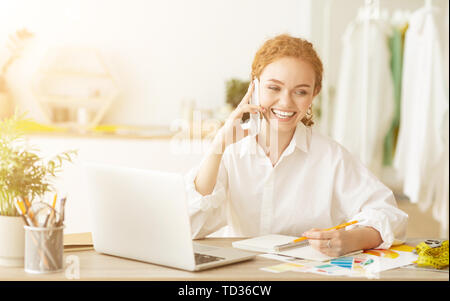 Discussing Order. Designer Talking On Phone In Workshop Stock Photo