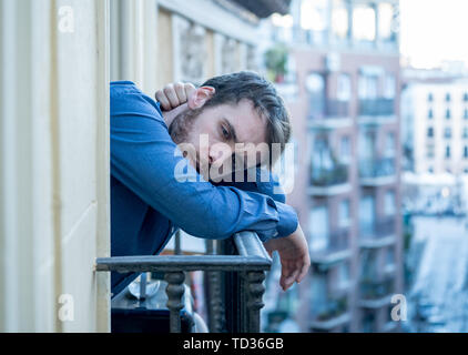 Lonely sad man staring outside house balcony feeling depressed distress and miserable. Suffering emotional crisis thinking about difficult important l Stock Photo