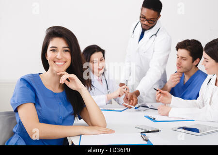 Meeting Of Medical Pros. Nurse Smiling To Camera At Meeting Stock Photo