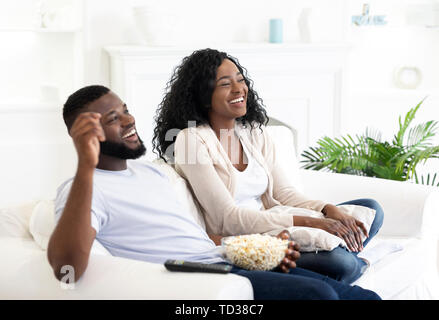 Euphoric teen couple watching tv at home Stock Photo