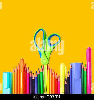 Back to school background with colorful pencils, scissors, markers on yellow backdrop, isolated. Stock Photo