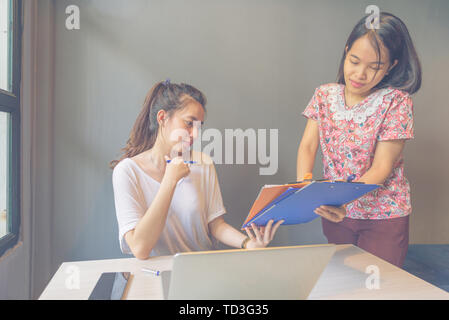 Asian office woman reading reports documents in the office Stock Photo