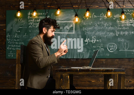 Mature tutor teacher giving private lessons to preschool boy, Teacher drawing at classroom in school, Concept education - back to school on green Stock Photo