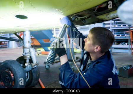 Tyumen, Russia - June 5, 2019: Aircraft repair helicopter UTair Engineering plant. Worker maintaining a Mi-8 helicopter Stock Photo
