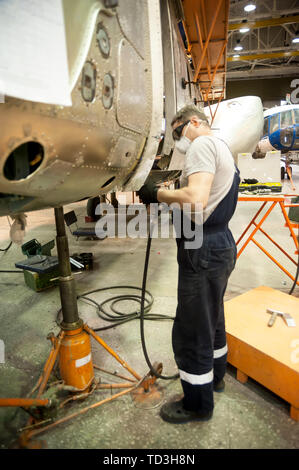 Tyumen, Russia - June 5, 2019: Aircraft repair helicopter UTair Engineering plant. Worker maintaining a Mi-8 helicopter Stock Photo