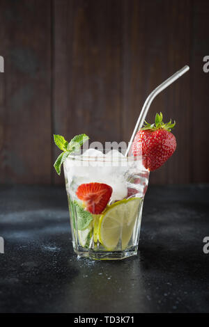 Detox lemonade or mojito with lime, lemon, strawberry in rocks glass. Summer healthy drink.