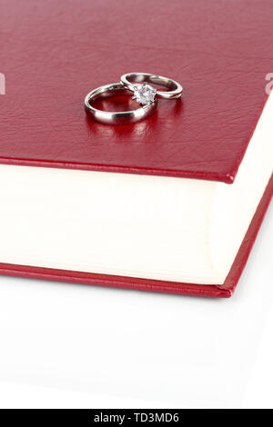 Wedding rings on bible isolated on white Stock Photo