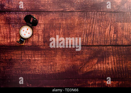 Isolated compass on a brown aged wooden table. Stock Photo