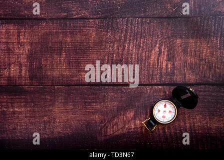 Isolated compass on a brown aged wooden table, copy space. Stock Photo