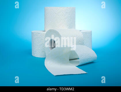 stacked rolls of toilet paper on sky blue background Stock Photo