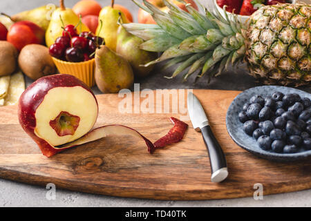 Preparing Fresh Mixed Colorful Fruit Salad on Wood Cutting Board. Diet and Healthy Eating Concept. Stock Photo