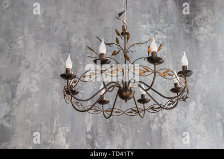 luxurious black metal chandelier hanging on the ceiling.contemporary chandelier, is a branched ornamental light fixture designed to be mounted on Stock Photo