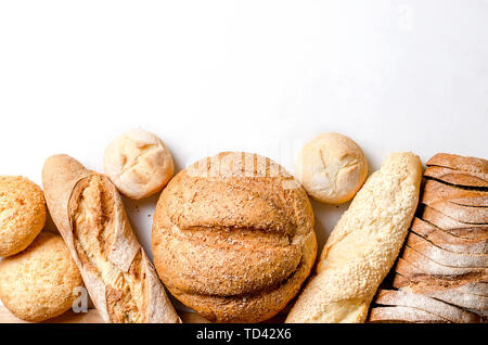 assortment of different types of bread, loaf, baguettes, loaves, rolls with ears of wheat on white background, healthy concept, copy spase, bakery pro Stock Photo