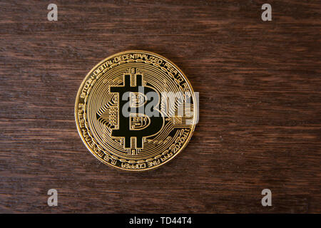 Bitcoin gold coin on dark wood background Stock Photo