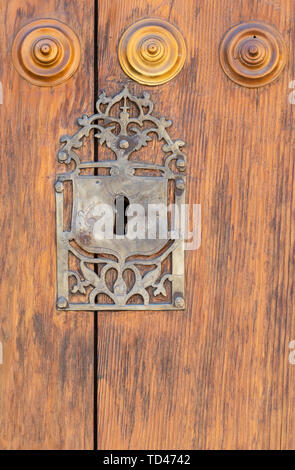 Keyhole in an old paneled wooden door; rusty and weathered Stock Photo