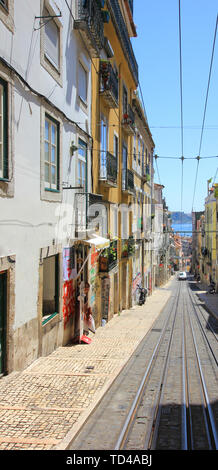 steep alley with the reails of the bica elevator in lisbon Stock Photo