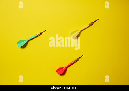 Single yellow, green and red arrows darts isolated on yellow background Stock Photo
