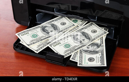 Printer printing fake dollar bills on wooden background Stock Photo