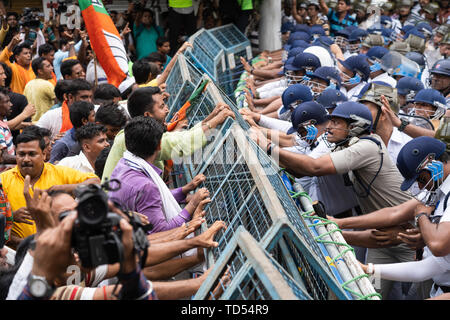 Kolkata, India. 12th June, 2019. Kolkata, India. 12th June, 2019. Bharatiya Janata Party (BJP) activists attempt to break through a police barricade during the protest in Kolkata. Bharatiya Janata Party workers protest against the killings of the BJP workers and also highlighting the alleged deterioration of law and order in the state, the Police used water cannons and tear gas shells towards the protesters who held a rally at Kolkata Police headquarters. Credit: SOPA Images Limited/Alamy Live News Stock Photo