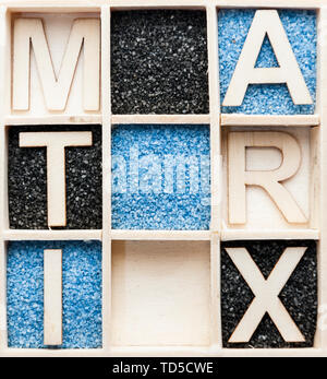 Wooden box with 3 x 3 square compartments partly with blue or black decorative sand and with the letters M, A, T, R, I and X. Stock Photo