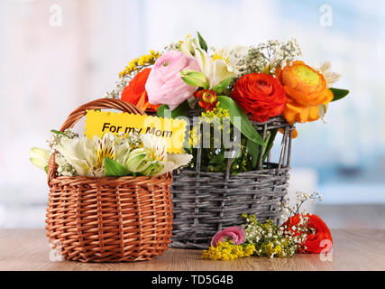 Many different flowers in baskets on room background Stock Photo