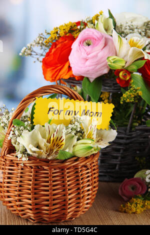 Many different flowers in baskets on room background Stock Photo