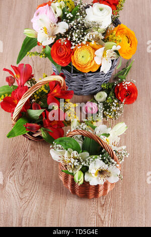 Many different flowers in baskets on light background Stock Photo