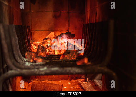 Bright hot coals and burning woods in bbq grill pit. Glowing and flaming charcoal, barbecue, red fire and ash. Weekend recreation background. Close-up Stock Photo