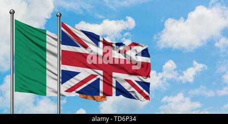 Ireland and United Kingdom flag waving in the wind against white cloudy blue sky together. Diplomacy concept, international relations. Stock Photo