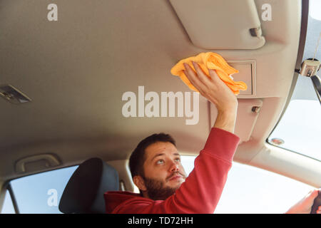 Photo on side of male with orange rag washing salon of car Stock Photo
