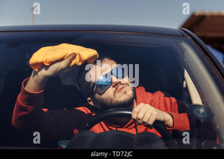 Photo of male with orange rag washing windshield Stock Photo