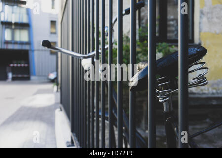 Old bicycle at the fence rods Stock Photo