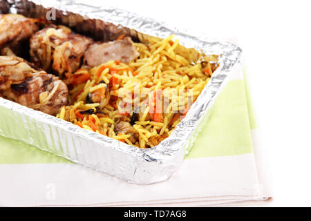 Food in box of foil on napkin  isolated in white Stock Photo
