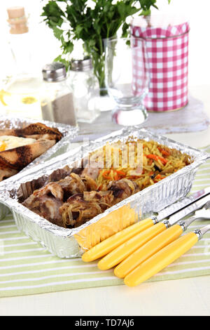 Food in boxes of foil on tablecloth Stock Photo
