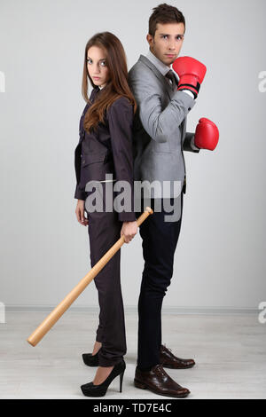 Armed young business people on grey background Stock Photo