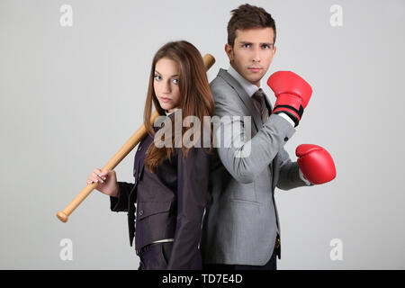 Armed young business people on grey background Stock Photo