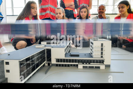 13 June 2019, Saxony-Anhalt, Dessau-Roßlau: Together with Bauhaus guide Carsten Brinzing, students from the Dessau Peace School look at a model of the Bauhaus School in Dessau. On the so-called Bauhaus explorer tour, children are given playful access to Bauhaus objects in typography, photograms, paperwork or dancing. In the interactive tours and workshops, the children conquer objects, techniques and buildings of the well-known design school in three age categories as Bauhaus detectives (8 to 10 years), Bauhaus researchers (10 to 13 years) and Bauhaus experts (14 years and older). The program Stock Photo