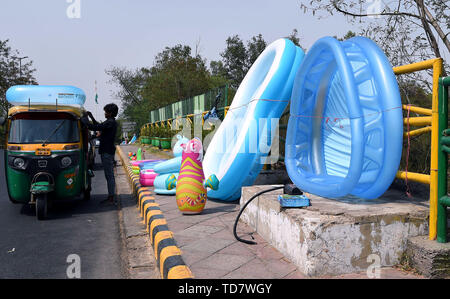 New Delhi, India. 13th June, 2019. People buy water toys for children in New Delhi, India, June 13, 2019. New Delhi is currently experiencing high temperatures as a heatwave continues across the country. Credit: Zhang Naijie/Xinhua/Alamy Live News Stock Photo