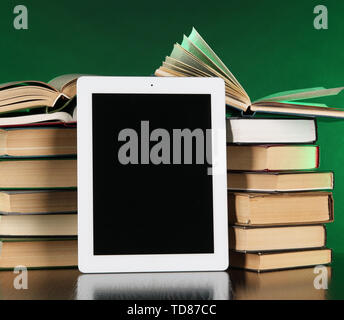 Tablet and books on bright background Stock Photo