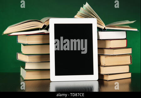 Tablet and books on bright background Stock Photo