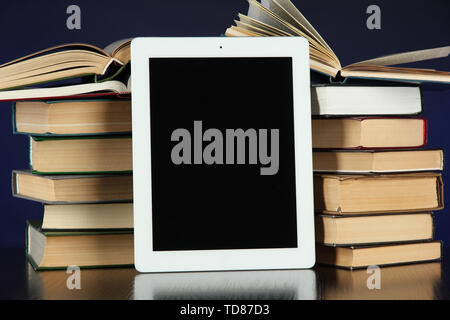 Tablet and books on bright background Stock Photo