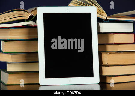 Tablet and books on bright background Stock Photo