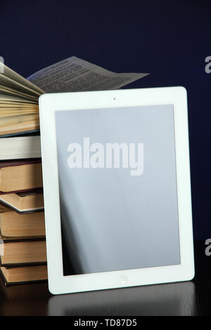 Tablet and books on bright background Stock Photo
