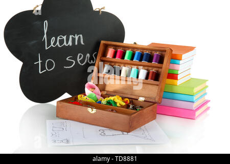 Sewing kit in wooden box and books isolated on white Stock Photo